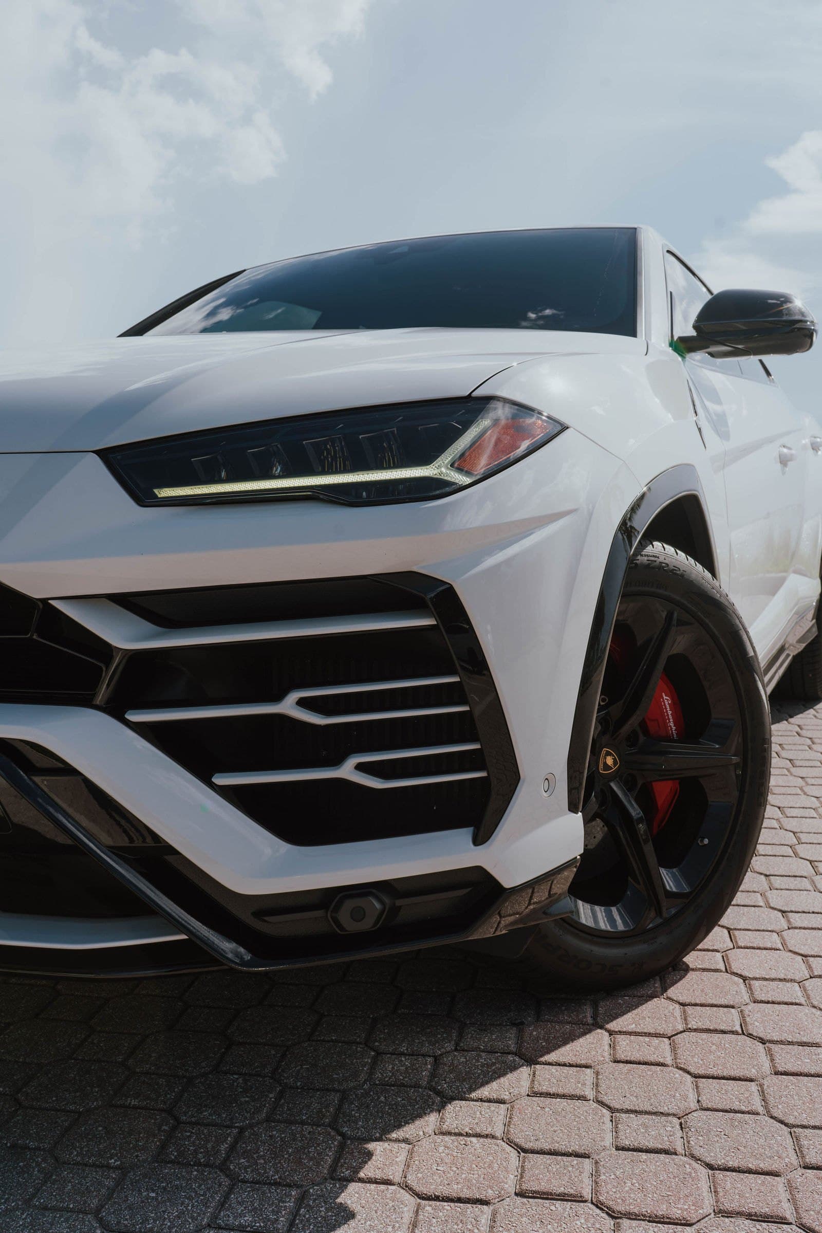 Front headlight detail of a white Lamborghini Urus